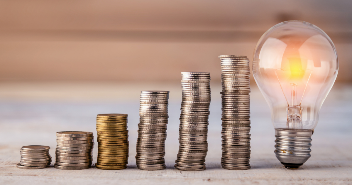 Stacks of coins building up in a line leading to a glowing light bulb - How Much of My Budget Should be Spent on Marketing?